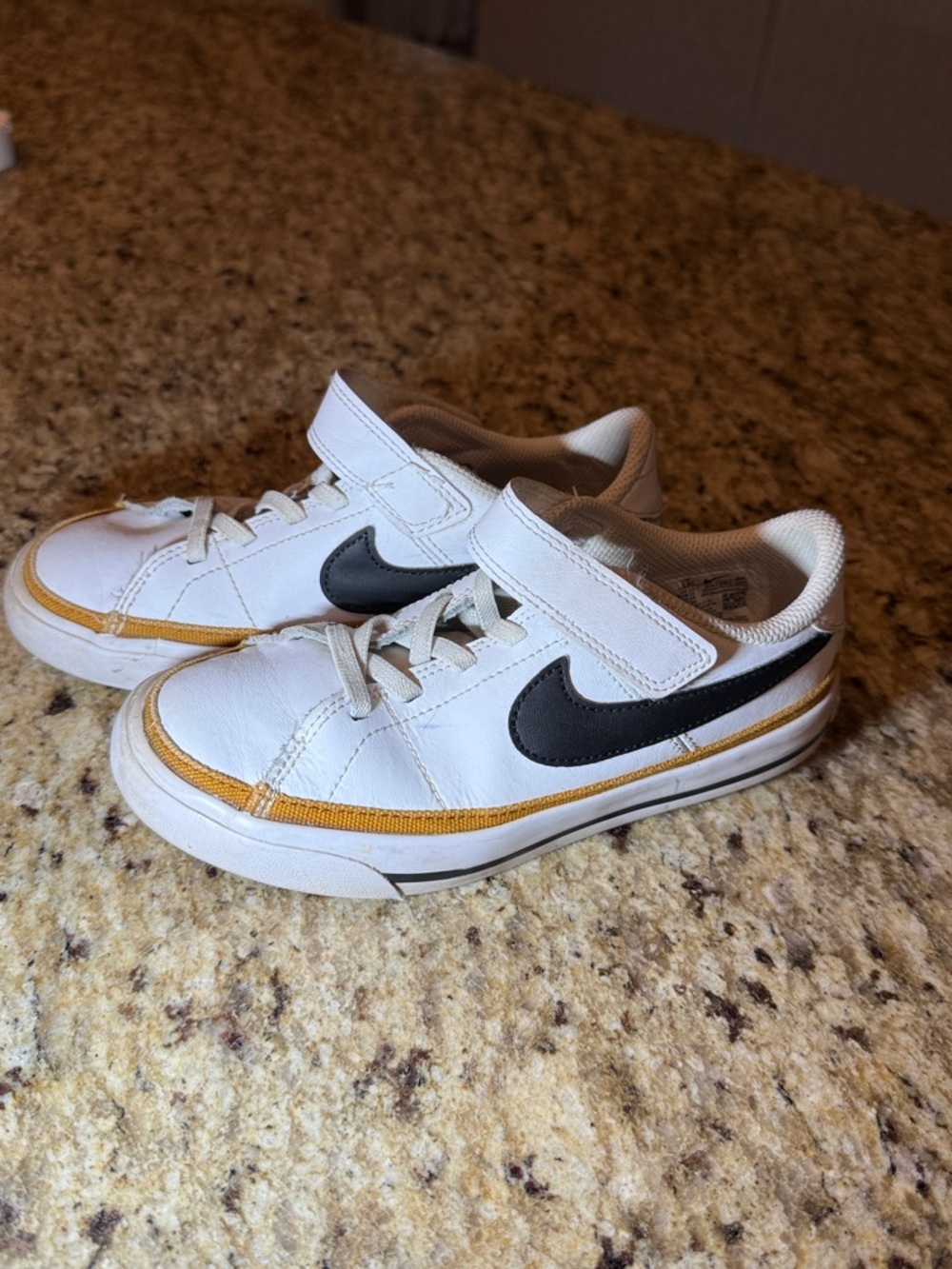 Nike Kids White Sneakers with Black Swoosh and Gold Trim